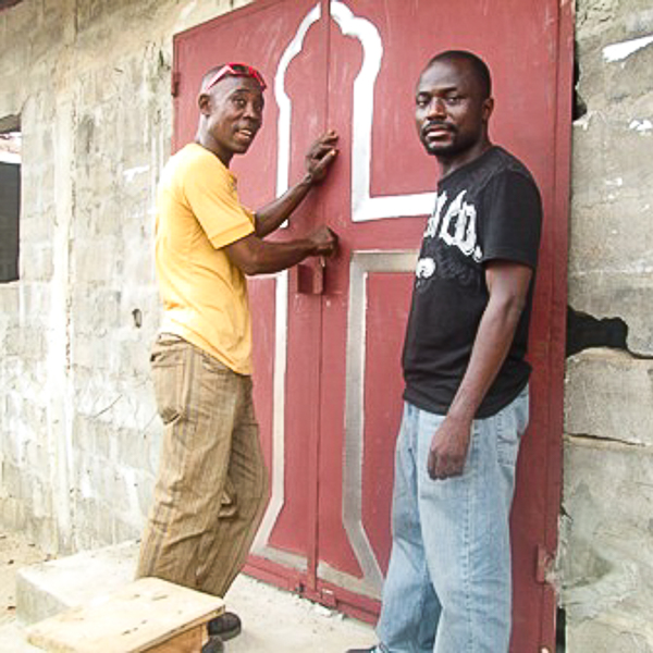 church leaders in Liberia stand next to a new door on a church building